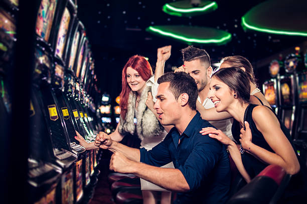 Group of people playing slot machinesc